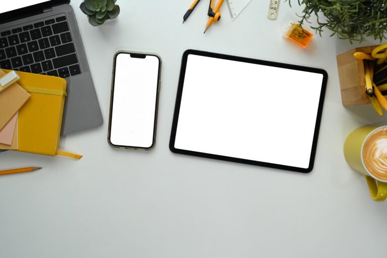 white office desk with digital tablet, laptop and supplies. flat lay, top view with copy space