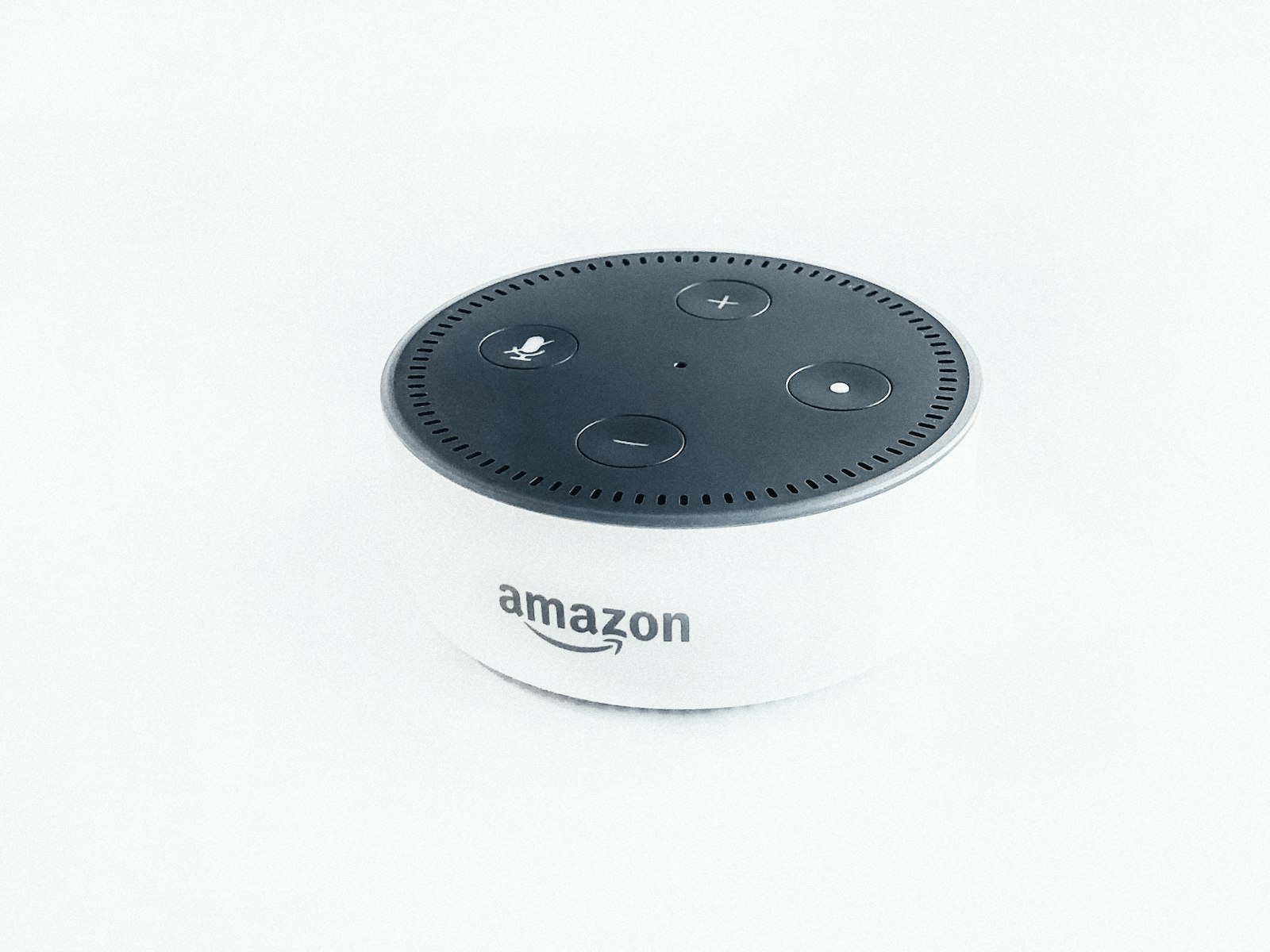 White Amazon Echo Dot smart speaker on a plain white surface, photographed from above.